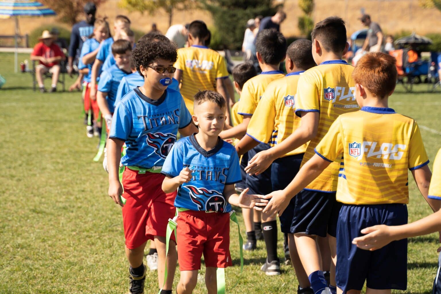 kids high-fiving other team after flag football game